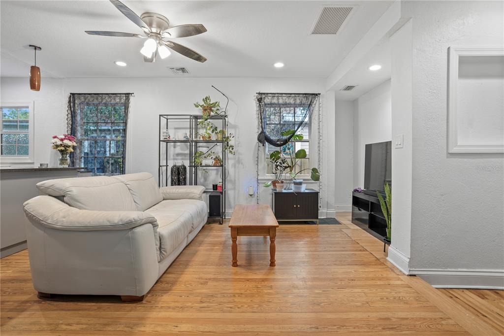 A living room features a beige sofa, a wooden coffee table, and a television console — 816 E JEFFERSON STREET, ORLANDO, FL