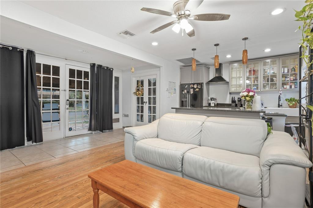 A living room with a white sofa and wooden coffee table opens to a kitchen — 816 E JEFFERSON STREET, ORLANDO, FL