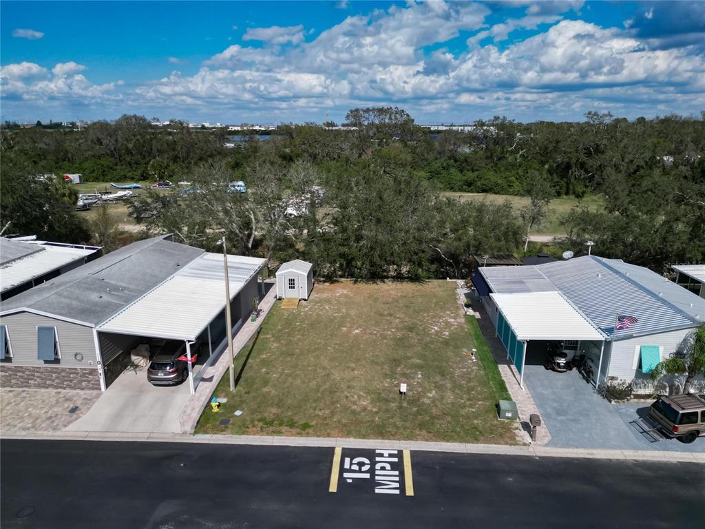 An aerial view shows a vacant lot situated between two manufactured homes with carports — 223 N SAINT GEORGE CIRCLE, APOLLO BEACH, FL