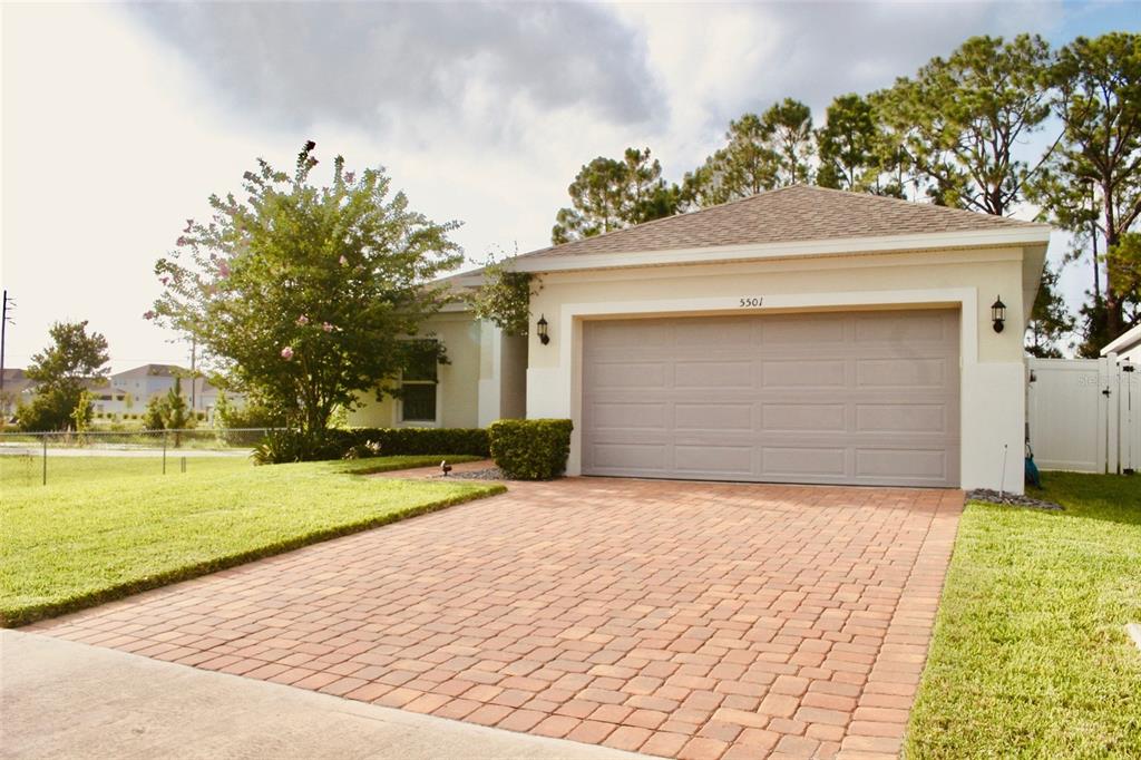 A front entrance features a black door, a brick walkway, and a manicured hedge — 5501 SABAL DRIVE, ST CLOUD, FL