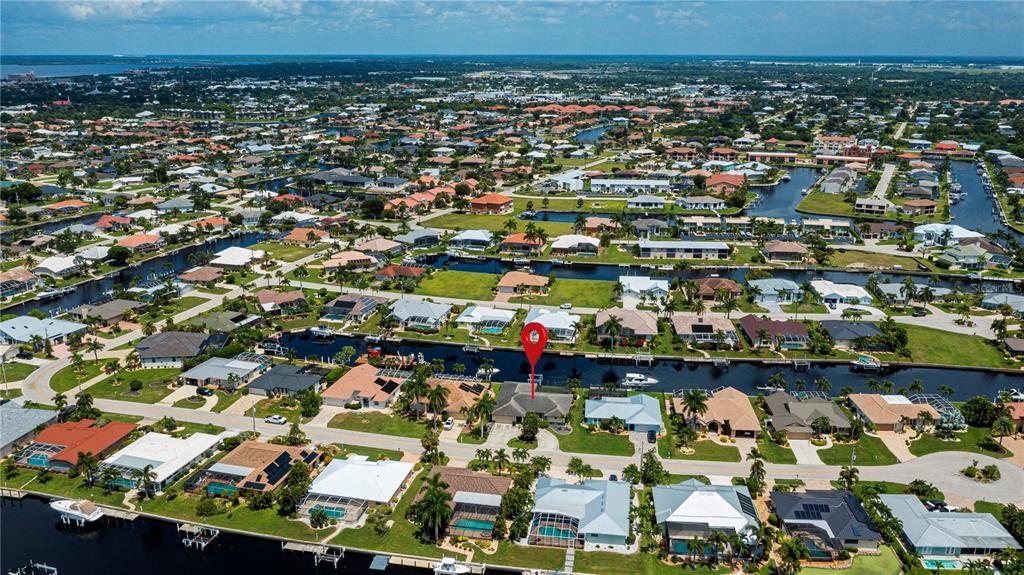 An aerial view shows a residential neighborhood with houses situated along a network of canals — 1205 VIA TRIPOLI, PUNTA GORDA, FL