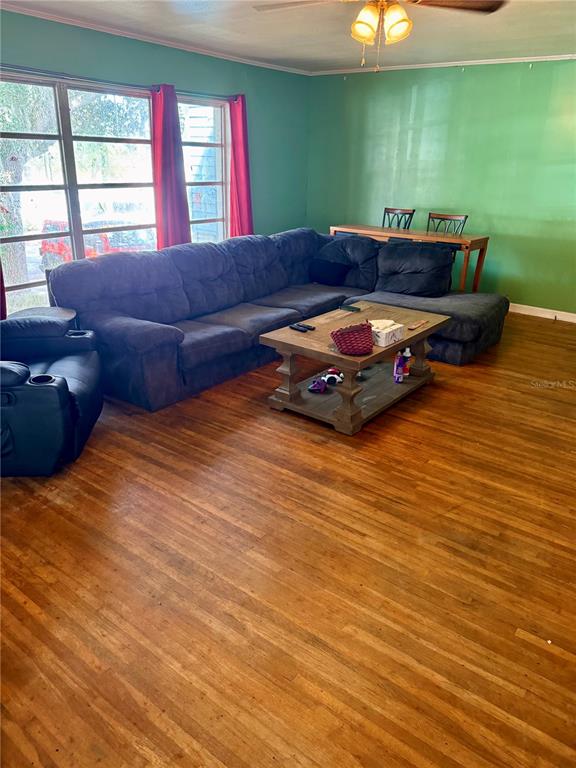 A living room features a large sectional sofa, a wooden coffee table, and hardwood floors — 104 13TH STREET SE, WINTER HAVEN, FL
