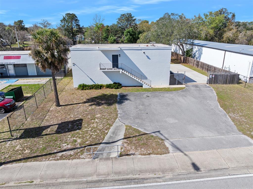 An exterior view of a white two-story building with an external staircase and paved lot — 974 S NOVA ROAD, ORMOND BEACH, FL