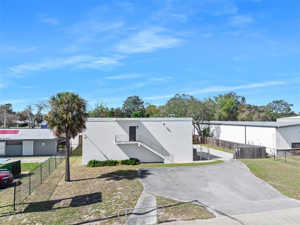 An exterior view of a white, flat-roofed building with an outdoor staircase leading to a door — 974 S NOVA ROAD, ORMOND BEACH, FL