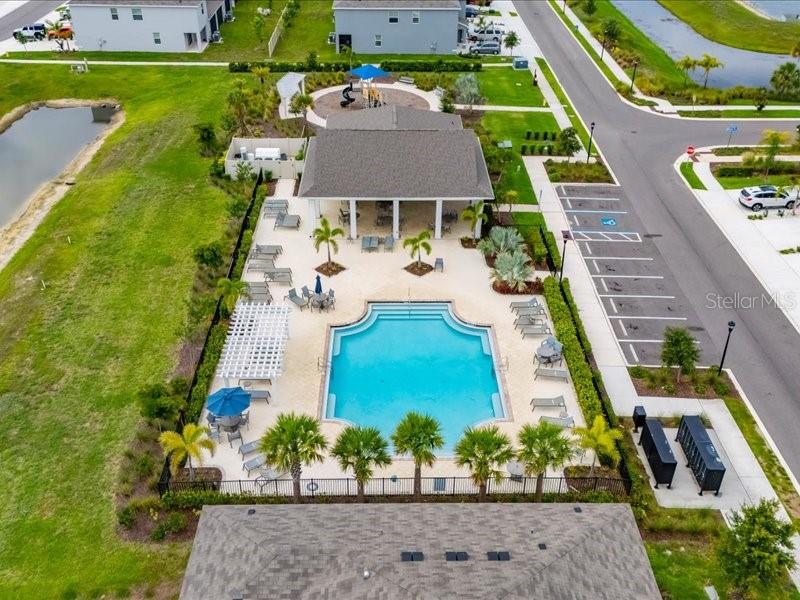 An open-concept kitchen and living area with white cabinets, tile flooring, and a sectional sofa — 416 MANGROVE SHADE CIRCLE, APOLLO BEACH, FL