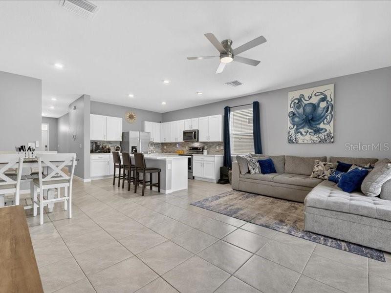 A living room features a sectional sofa, tile flooring, a ceiling fan, and sliding glass doors — 416 MANGROVE SHADE CIRCLE, APOLLO BEACH, FL