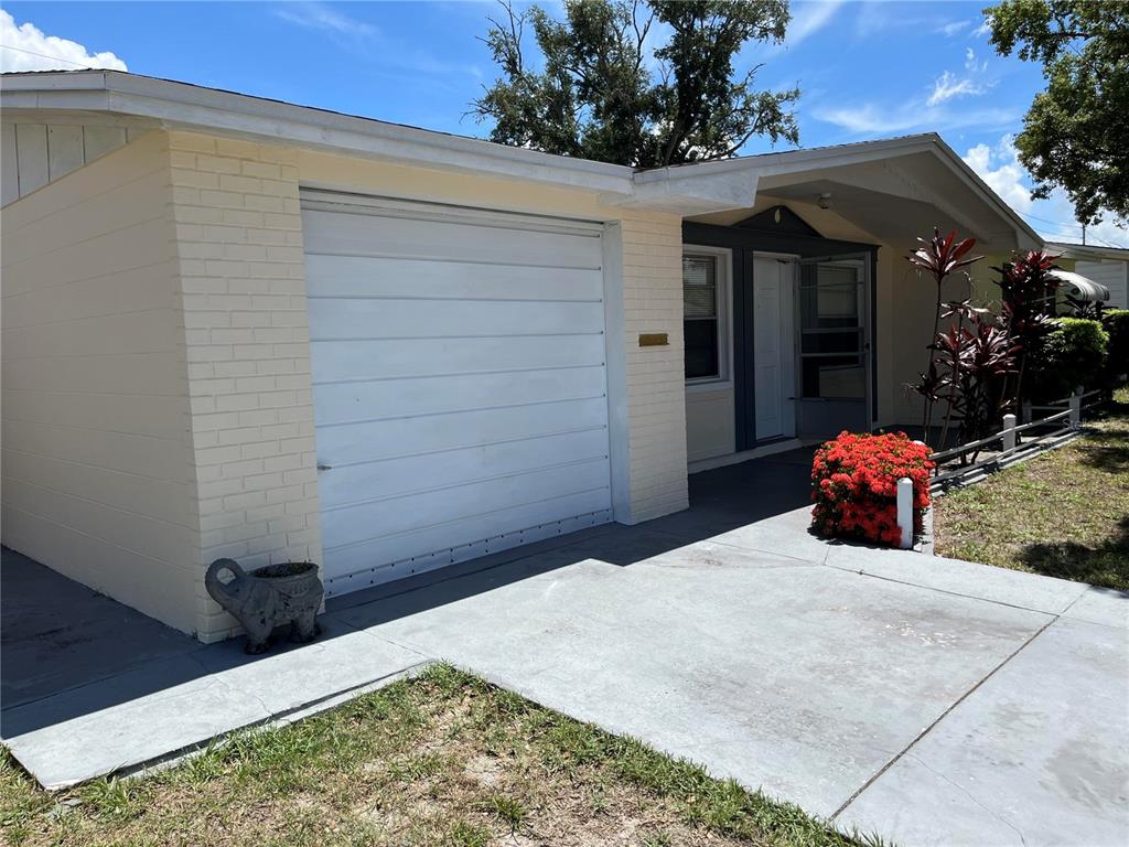A white, single-story house with a garage, a wooden privacy fence, and a concrete driveway — 3632 PENSDALE DRIVE, NEW PORT RICHEY, FL