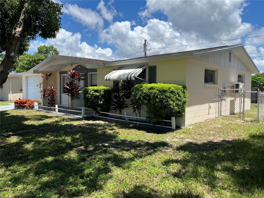 A garage features a workbench with a pegboard, a microwave, and an open ceiling — 3632 PENSDALE DRIVE, NEW PORT RICHEY, FL