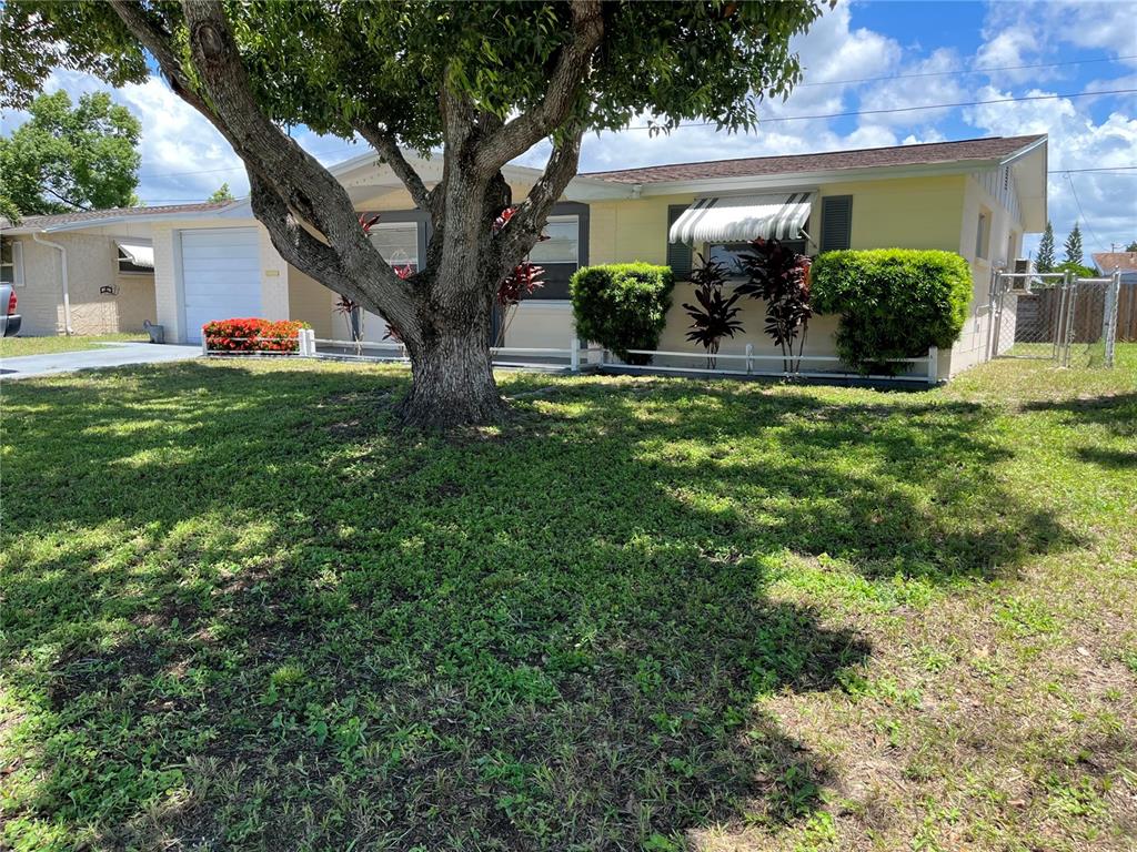 A kitchen features stainless steel appliances, white cabinetry, and light-colored tile flooring — 3632 PENSDALE DRIVE, NEW PORT RICHEY, FL