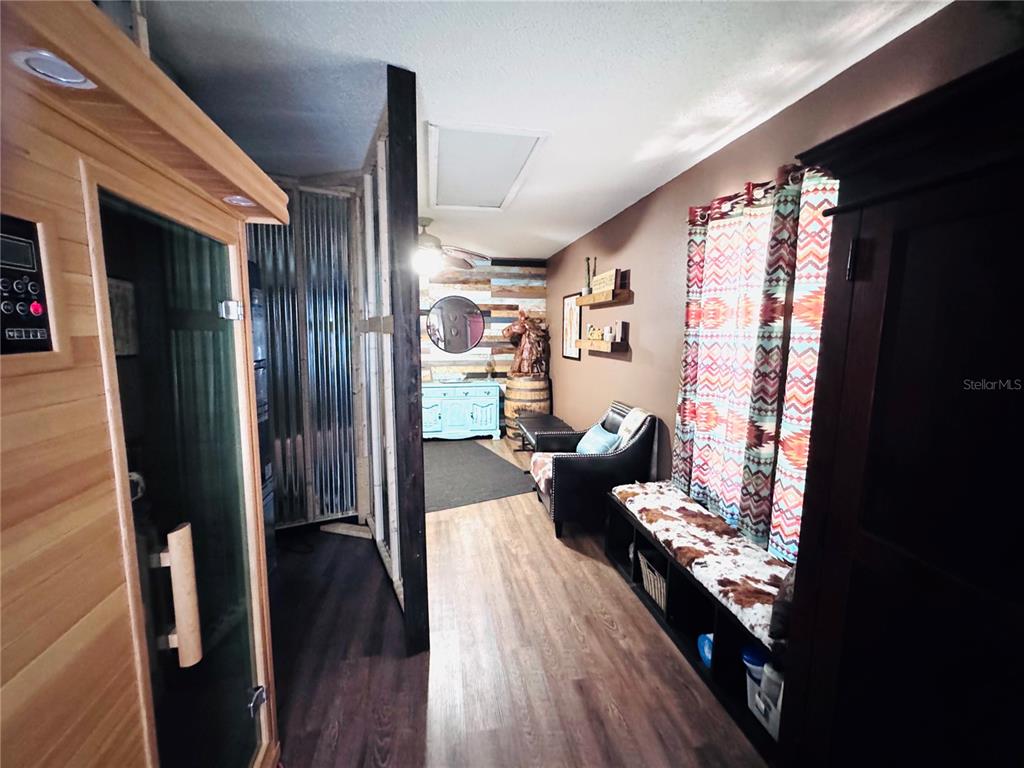 A room features a wooden sauna, a corrugated metal partition, and a bench with cowhide upholstery — 7590 N CAESAR POINT, DUNNELLON, FL
