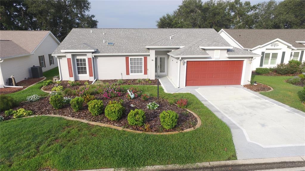 A single-story house with light gray siding, a red garage door, and a landscaped front yard — 4755 TARA VIEW ROAD, LEESBURG, FL