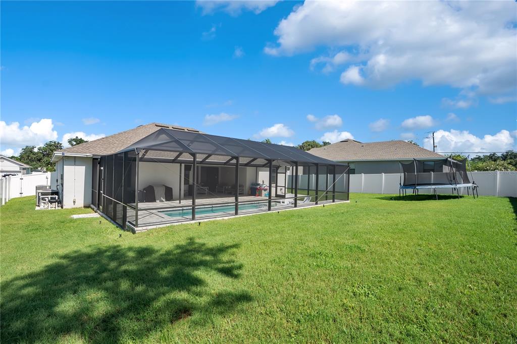 An aerial view shows three suburban houses with attached garages and green lawns — 525 GANDHI DRIVE, LAKELAND, FL