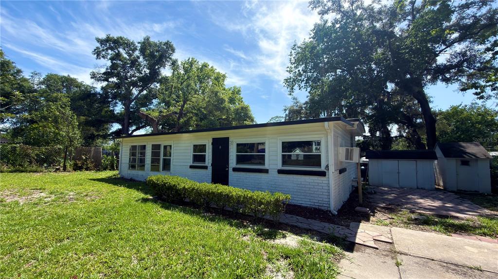 A white brick house with a black door and window frames sits on a grassy lot — 11772 SE 99TH TERRACE, BELLEVIEW, FL