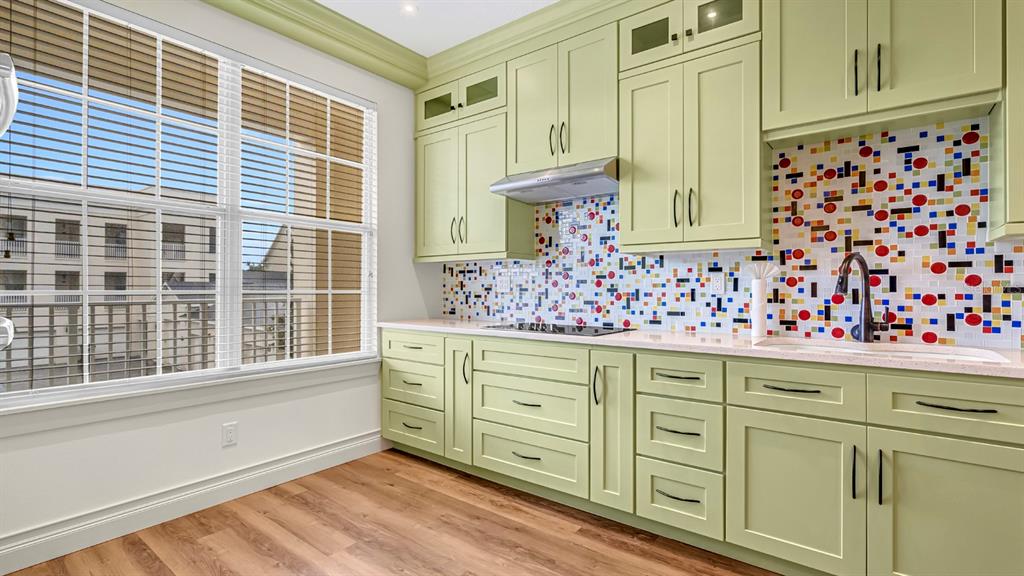 A dining area with a wooden table and chairs sits adjacent to a white kitchen — 4286 ANISSA AVENUE UNIT 10-202, ORLANDO, FL