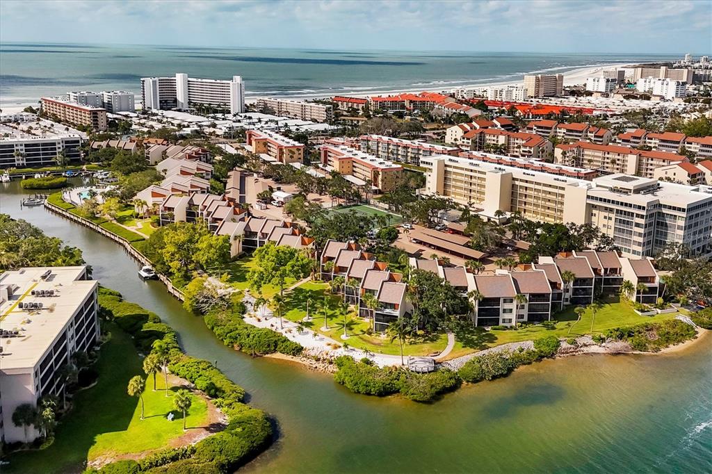An aerial view of a coastal resort complex featuring multiple buildings, lush landscaping, and waterways — 1900 COVE II PLACE UNIT 127, SARASOTA, FL