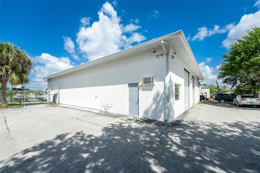 A white commercial building exterior with a gray door, a window, and a parking lot — 4159 ELECTRIC WAY, PUNTA GORDA, FL