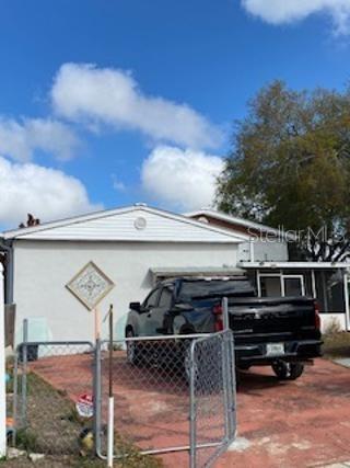 A black pickup truck is parked on a paved driveway in front of a house — 312 MILAKEE AVENUE, SEBRING, FL