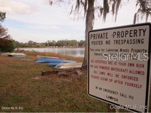 A sign warns against trespassing on private property near a lake with several small boats — 7TH LOOP, SILVER SPRINGS, FL