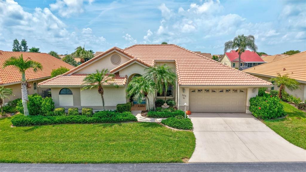 A single-story house with a tiled roof, beige stucco exterior, and a two-car garage — 103 INLETS BOULEVARD UNIT 103, NOKOMIS, FL