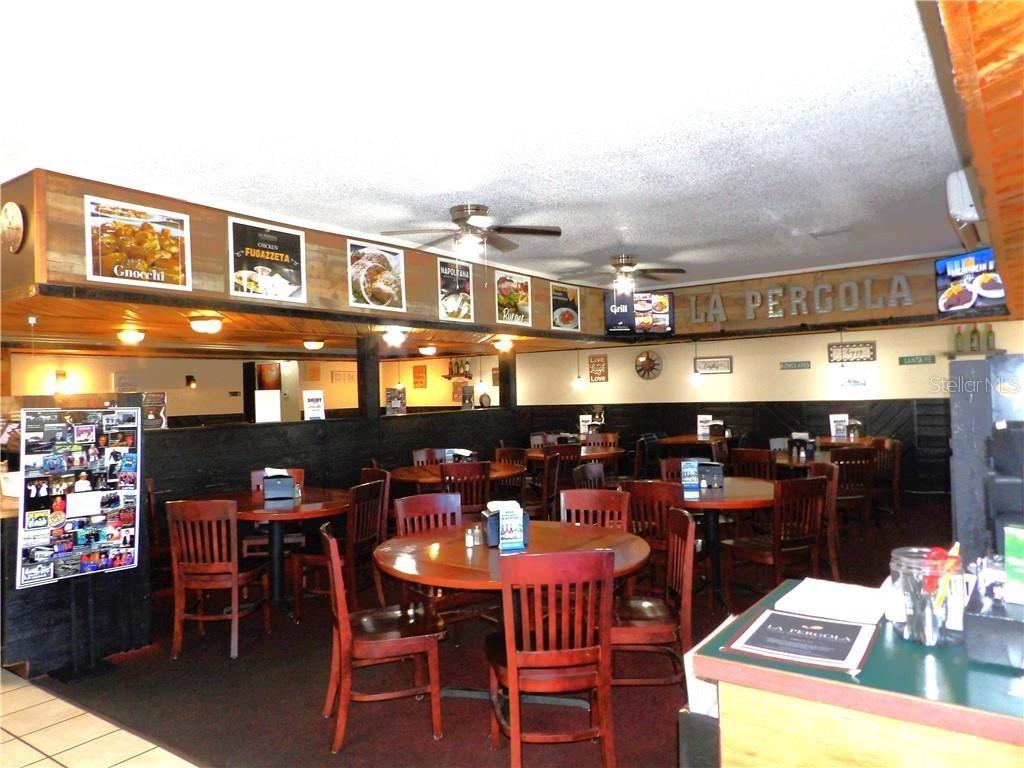 The interior of a restaurant features wooden tables, chairs, and framed food photos on walls — 2780 N FLORIDA AVENUE, HERNANDO, FL