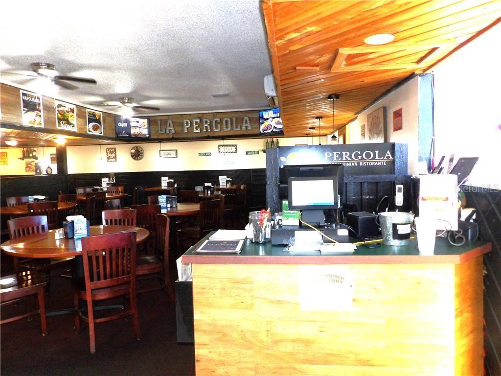 A restaurant interior features wooden tables, chairs, a service counter, and a wood-paneled ceiling — 2780 N FLORIDA AVENUE, HERNANDO, FL