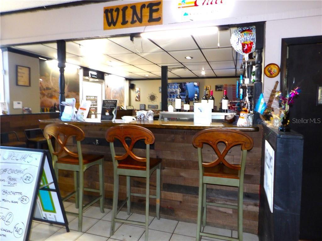 A bar area features three wooden chairs, a wood-paneled counter, and a wine sign — 2780 N FLORIDA AVENUE, HERNANDO, FL