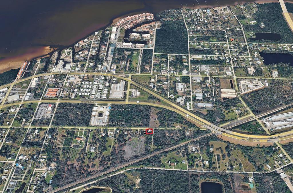 An aerial map view showing a wooded lot located near a highway and residential area — 1813 LAVILLA ROAD, PUNTA GORDA, FL