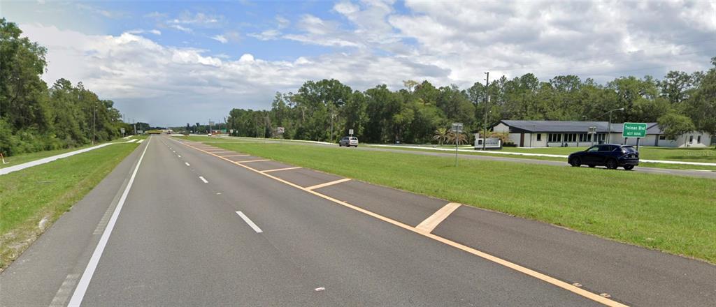 A view of a multi-lane road with a grassy median and a building in the distance — 34357 CORTEZ BOULEVARD, DADE CITY, FL