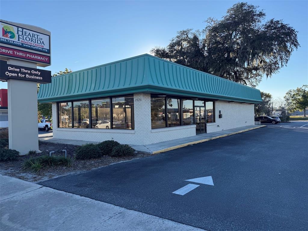 A single-story commercial building with a teal mansard roof and white brick exterior — 1536 S PINE AVENUE, OCALA, FL