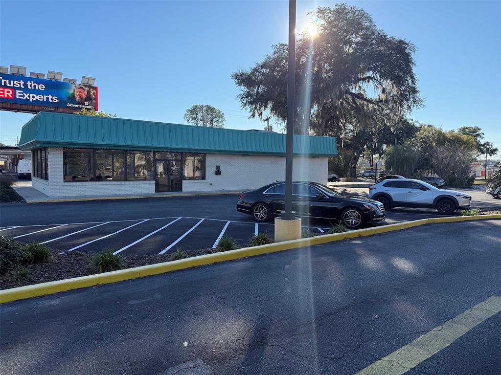 A single-story commercial building with a teal metal roof sits in a paved parking lot — 1536 S PINE AVENUE, OCALA, FL