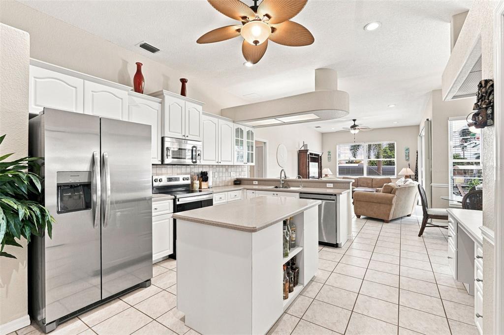 A screened-in patio features a swimming pool, outdoor furniture, and a light-colored house exterior — 136 PECKHAM STREET SE, PORT CHARLOTTE, FL