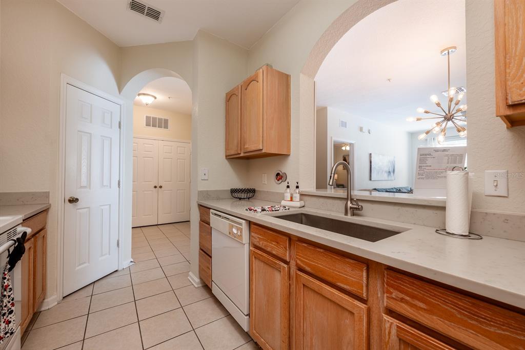 A kitchen features light wood cabinets, a stainless steel sink, and a white dishwasher — 2778 ALMATON LOOP UNIT 204, KISSIMMEE, FL