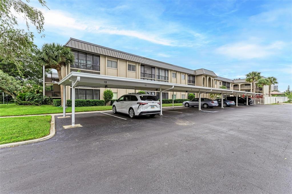 A multi-story apartment building with a covered parking area in front — 6470 HOLLYWOOD BOULEVARD UNIT 307, SARASOTA, FL