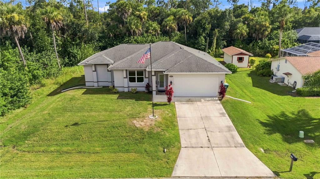 A single-story house with a gray roof, white exterior, and a concrete driveway — 22437 ADORN AVENUE, PORT CHARLOTTE, FL