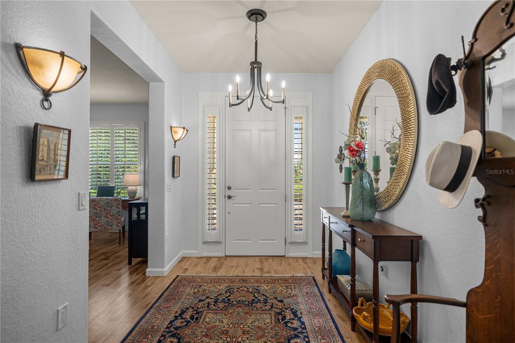 A foyer features a chandelier, a console table with a mirror, and a patterned area rug — 9383 SW 71ST LOOP, OCALA, FL