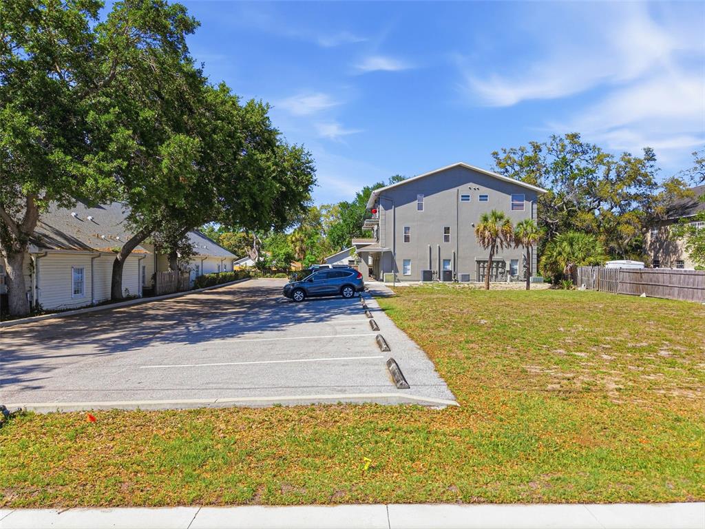A gray multi-story building stands next to a paved parking lot and a grassy area — 444 SKINNER BOULEVARD, DUNEDIN, FL