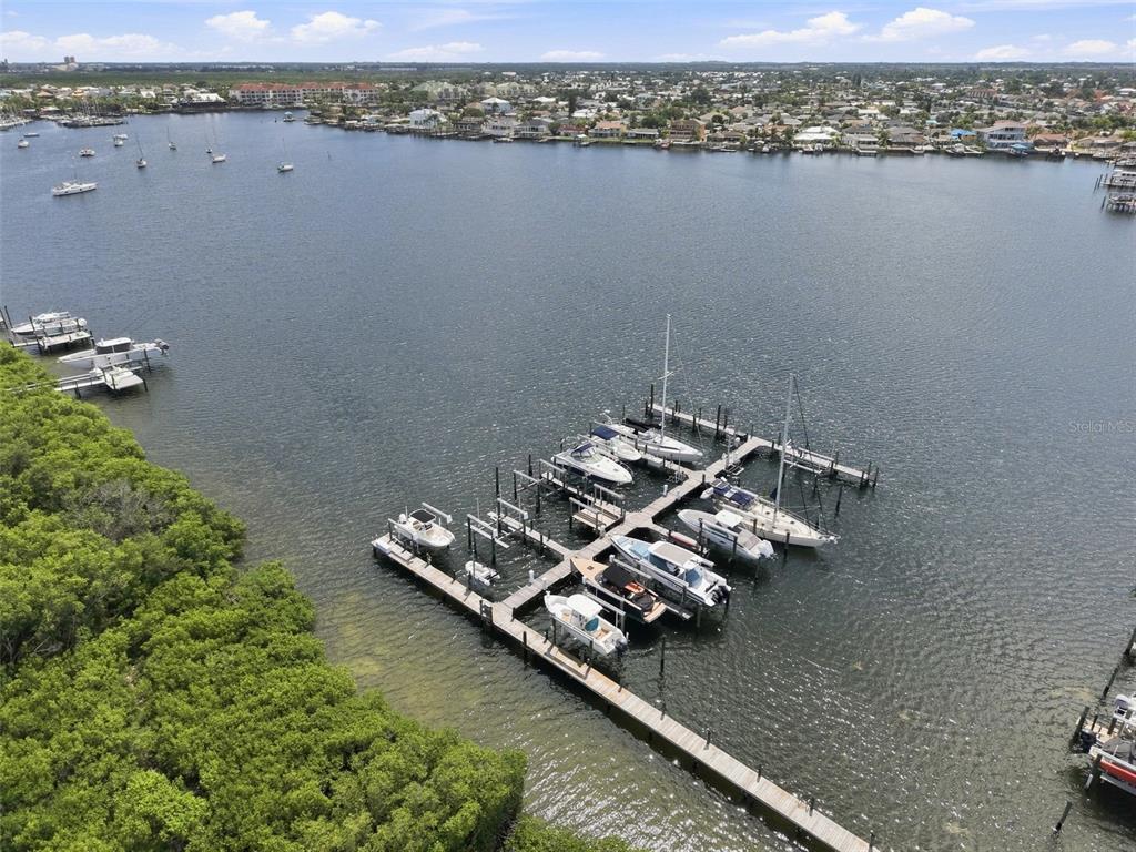 An aerial view shows a boat dock with several vessels moored in a calm bay — 6111 LAGOMAR LANE, APOLLO BEACH, FL