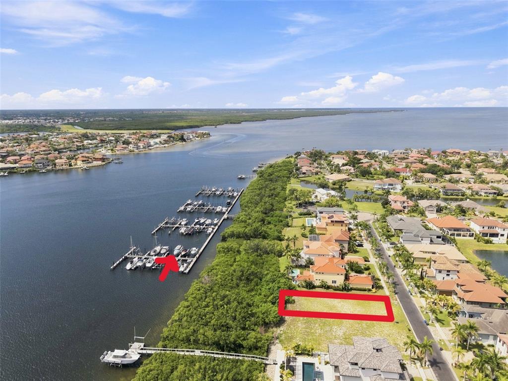 An aerial view shows a vacant residential lot next to a marina and waterfront homes — 6111 LAGOMAR LANE, APOLLO BEACH, FL