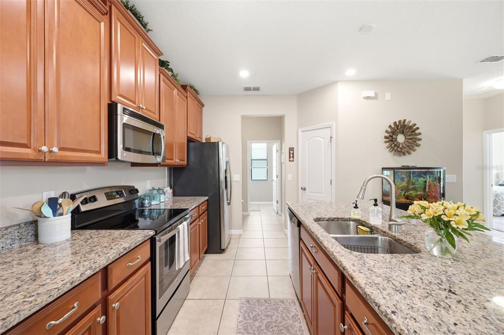An open-concept dining and living area features tile flooring, a chandelier, and a fish tank — 11767 LAKE BOULEVARD, NEW PORT RICHEY, FL