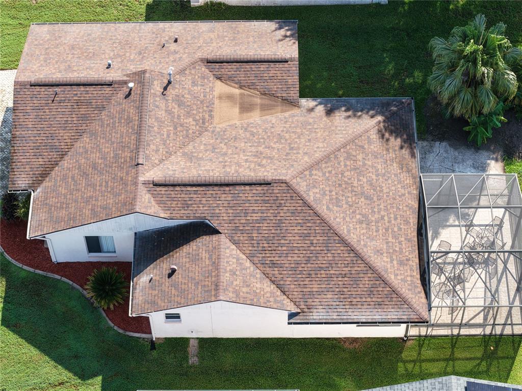 An aerial view shows the brown shingled roof of a house with a screened-in patio — 11226 SCENIC VIEW LANE, ORLANDO, FL