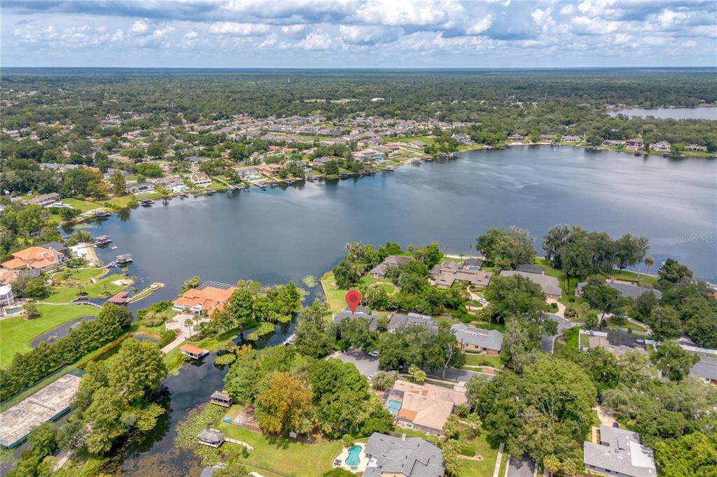 An aerial view shows a residential neighborhood situated along a large lake — 2260 W CLASSIC COURT, LONGWOOD, FL
