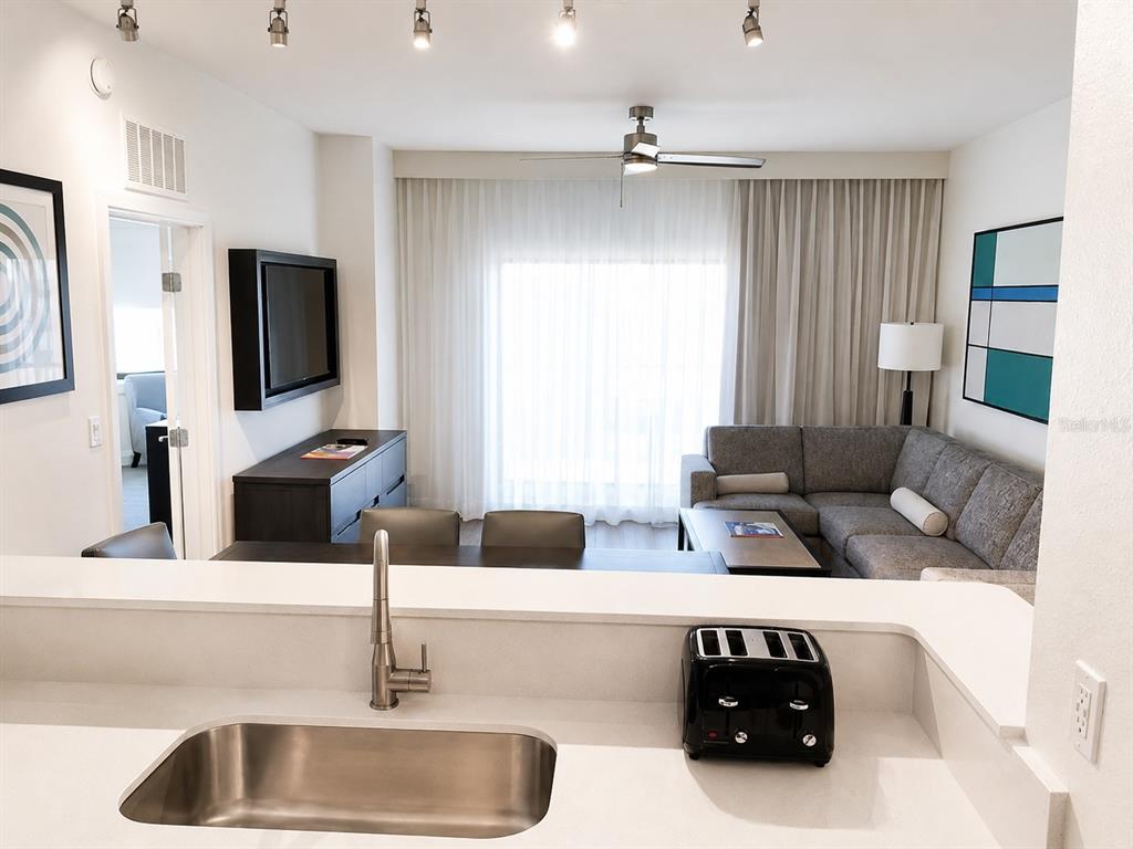 A kitchen features dark wood cabinets, stainless steel appliances, and white countertops — 14501 GROVE RESORT AVE UNIT 3701, WINTER GARDEN, FL
