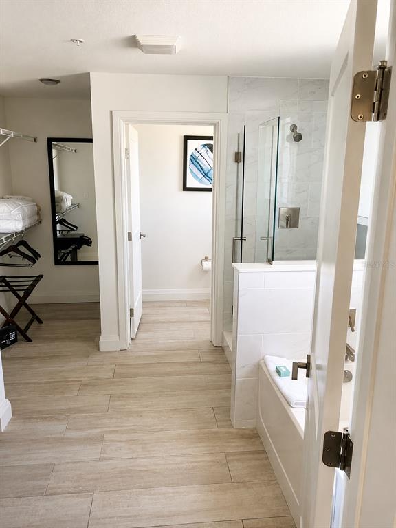 A bathroom with a walk-in shower, a soaking tub, and an adjacent walk-in closet — 14501 GROVE RESORT AVE, WINTER GARDEN, FL