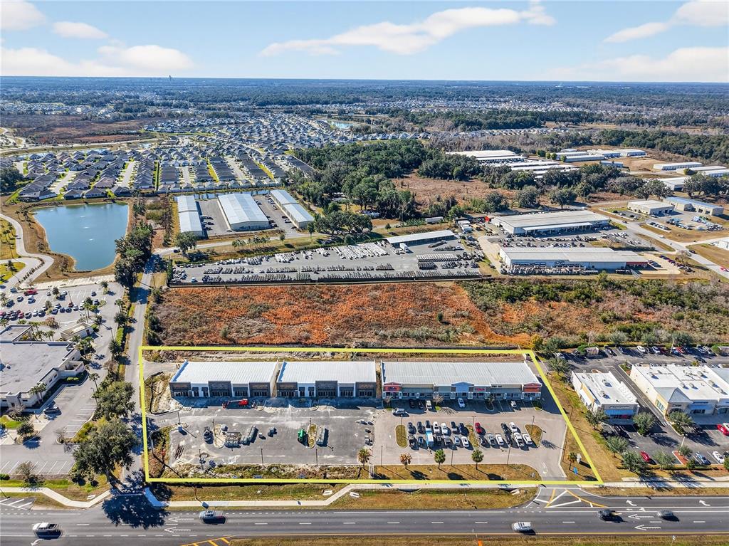 An aerial view shows a commercial strip mall with a parking lot outlined in yellow — 4713 E STATE ROAD 44, WILDWOOD, FL