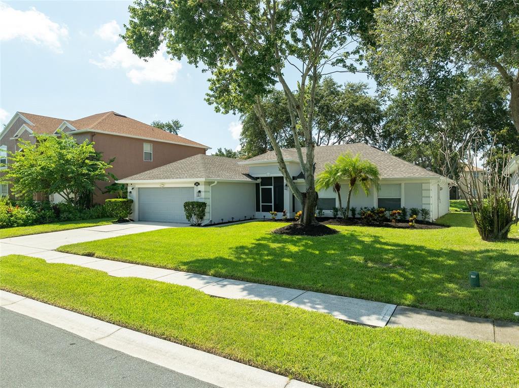 A single-story house with a gray garage, light-colored siding, and a large front lawn — 1373 PAYETTE LANE, WEST MELBOURNE, FL