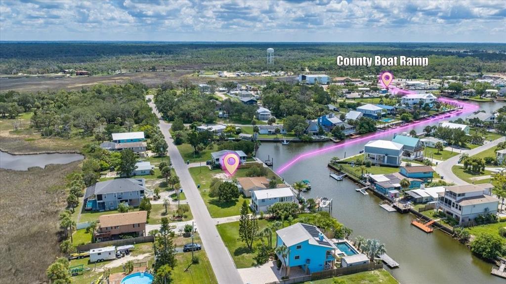 This aerial view shows a residential neighborhood with a canal and a county boat ramp — 4018 EAGLE NEST DRIVE, HERNANDO BEACH, FL