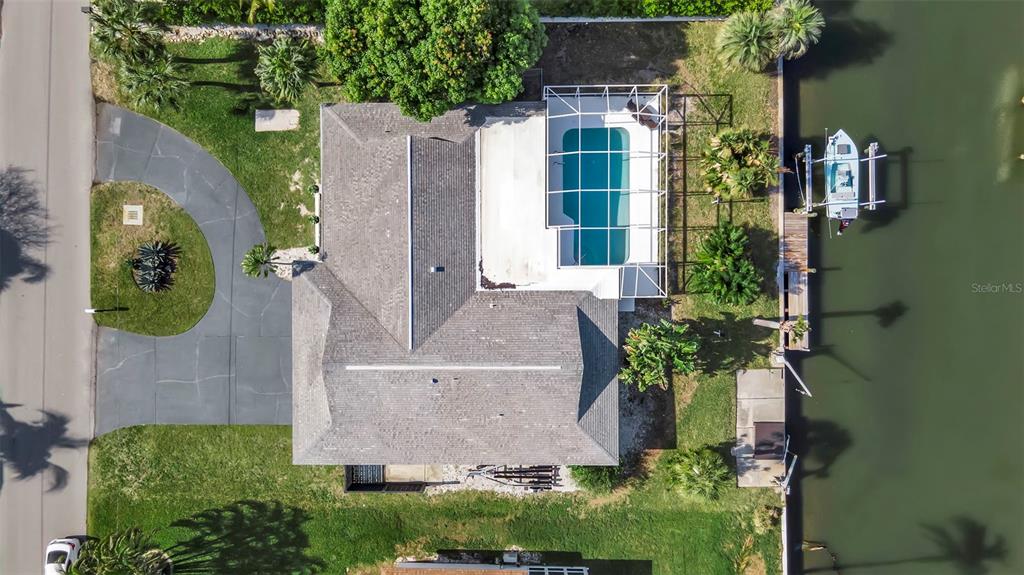 An aerial view shows a house with a screened pool, driveway, and boat dock — 1649 STANFORD LANE, SARASOTA, FL