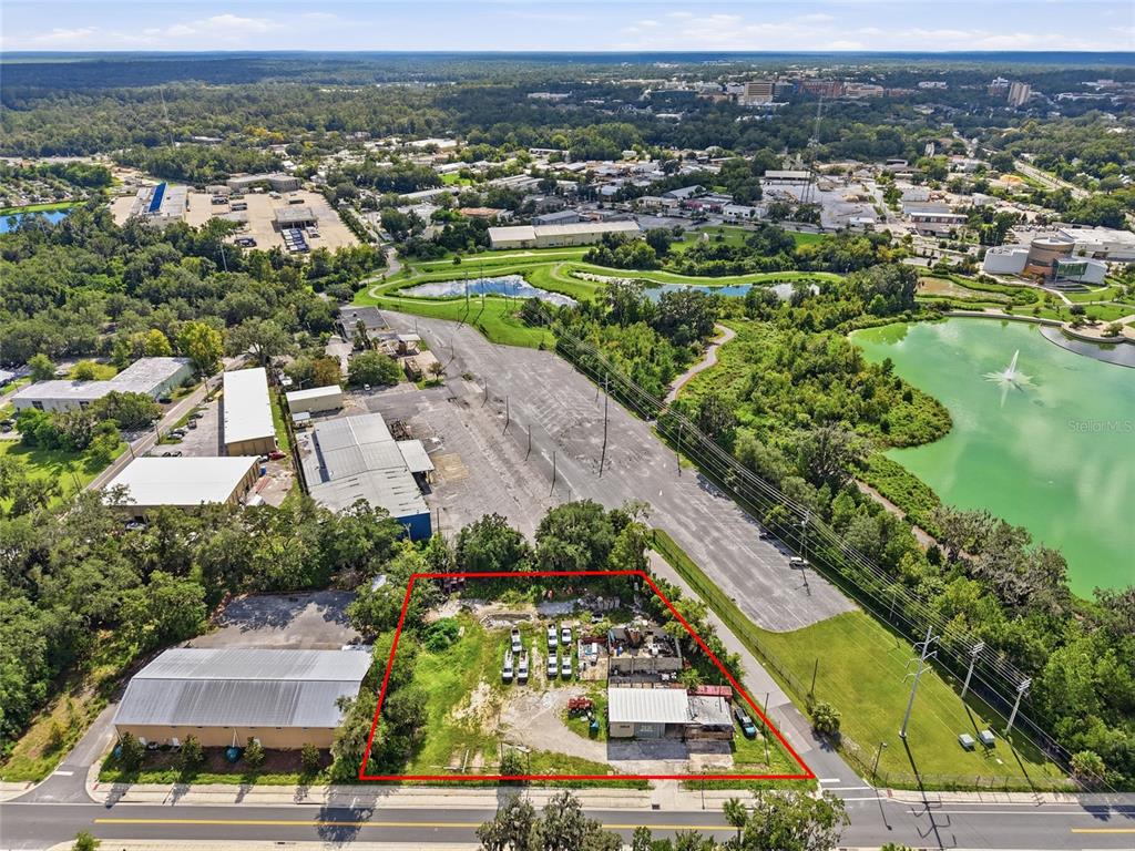 An aerial view shows a rectangular lot outlined in red containing a small industrial building — 916 SE 4TH STREET, GAINESVILLE, FL
