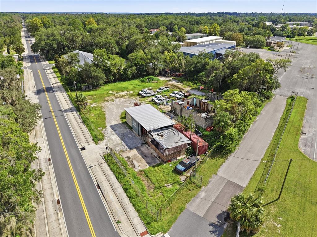 An aerial view shows a commercial property with a metal-roofed building and parked vehicles — 916 SE 4TH STREET, GAINESVILLE, FL