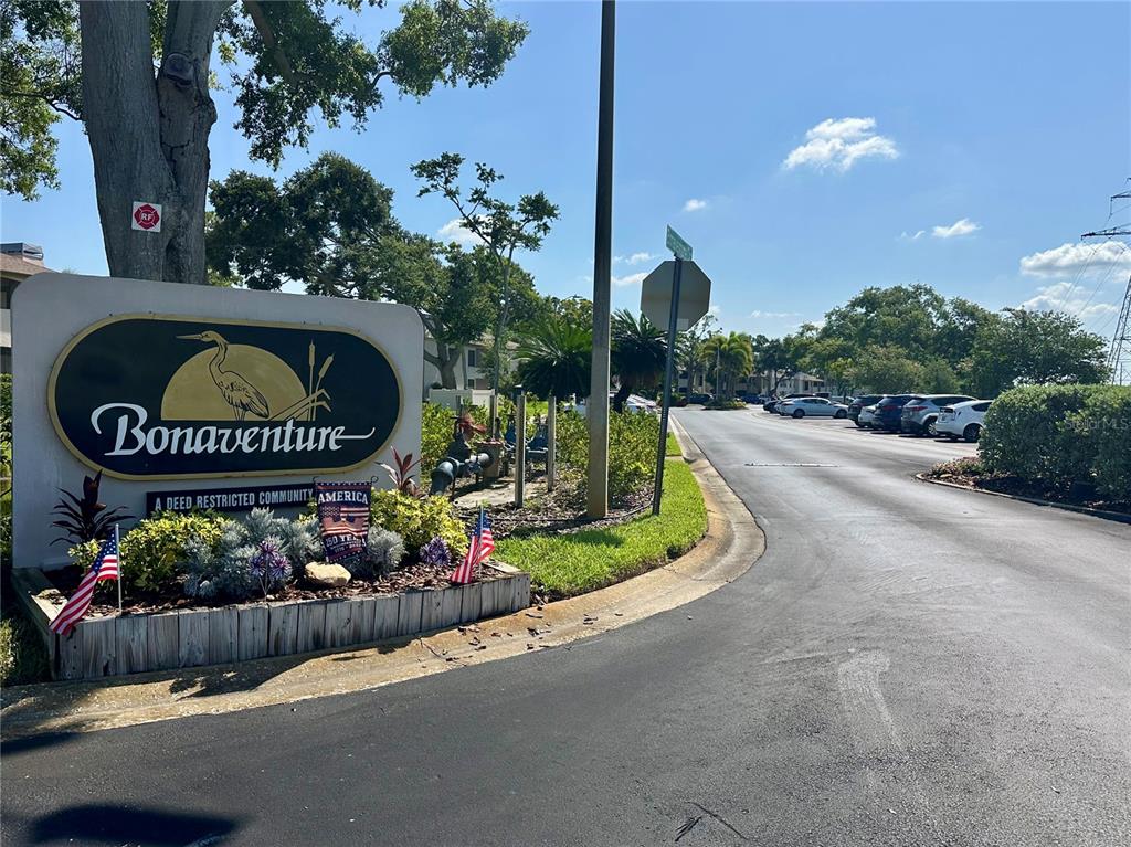 A sign for the Bonaventure community stands at the entrance to a paved road — 3004 BONAVENTURE CIRCLE UNIT 102, PALM HARBOR, FL